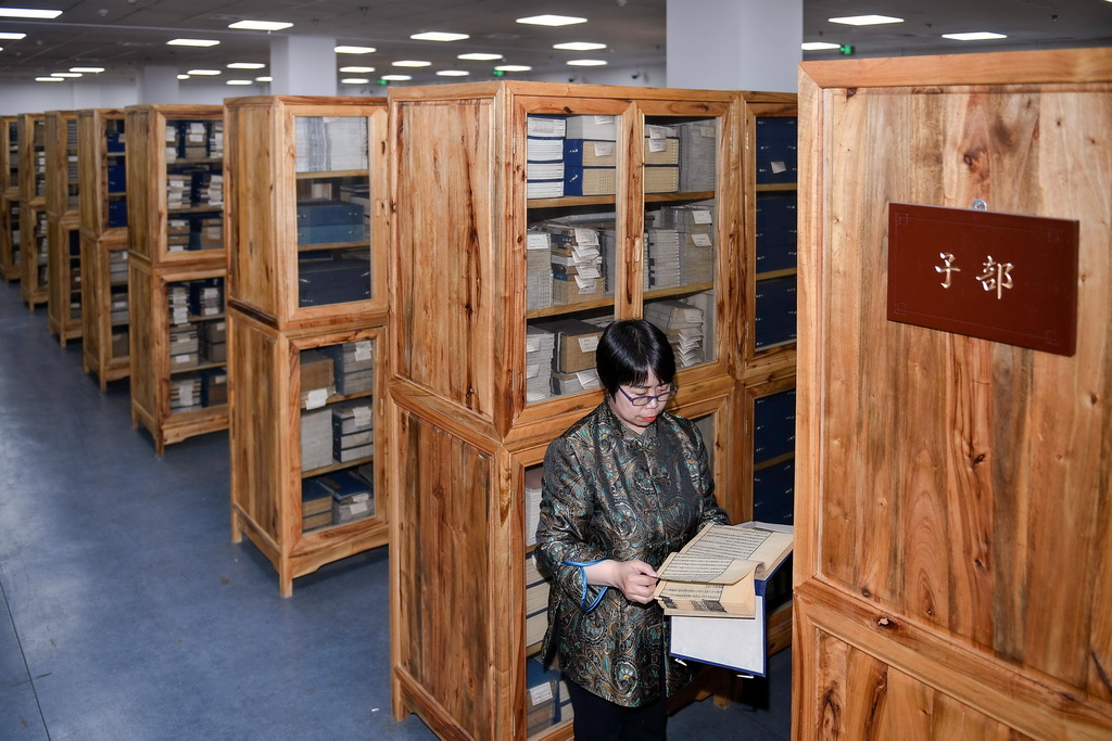 吉林大學圖書館古籍部主任王麗華在線裝書庫內查看古籍的保存狀況（4月19日攝）。