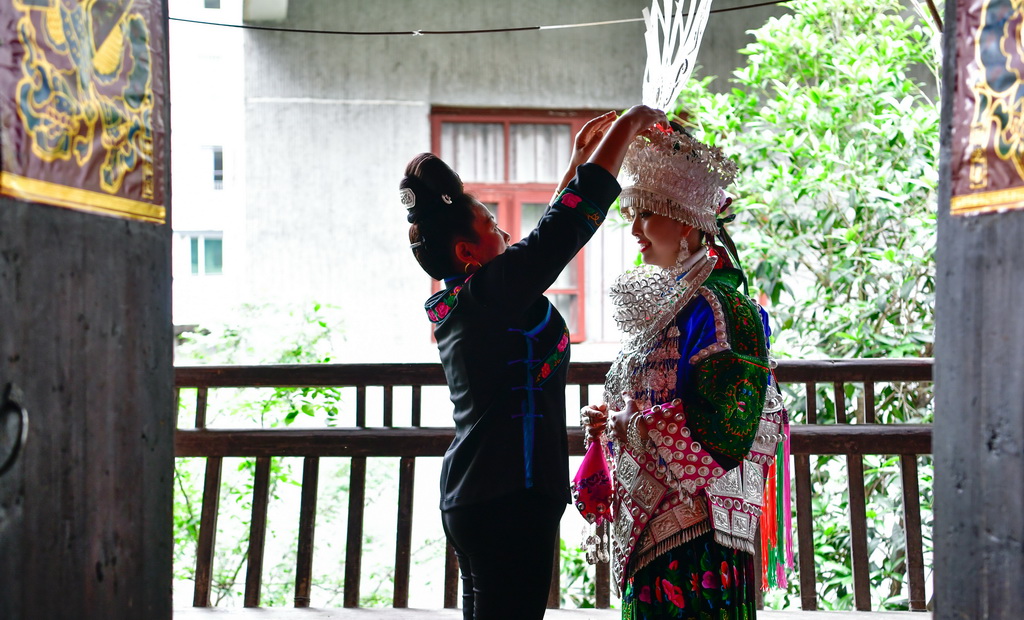 4月21日，在貴州省台江縣，一名苗族母親幫助女兒穿戴苗族銀飾，准備參加苗族姊妹節盛裝游演。新華社記者 楊文斌 攝