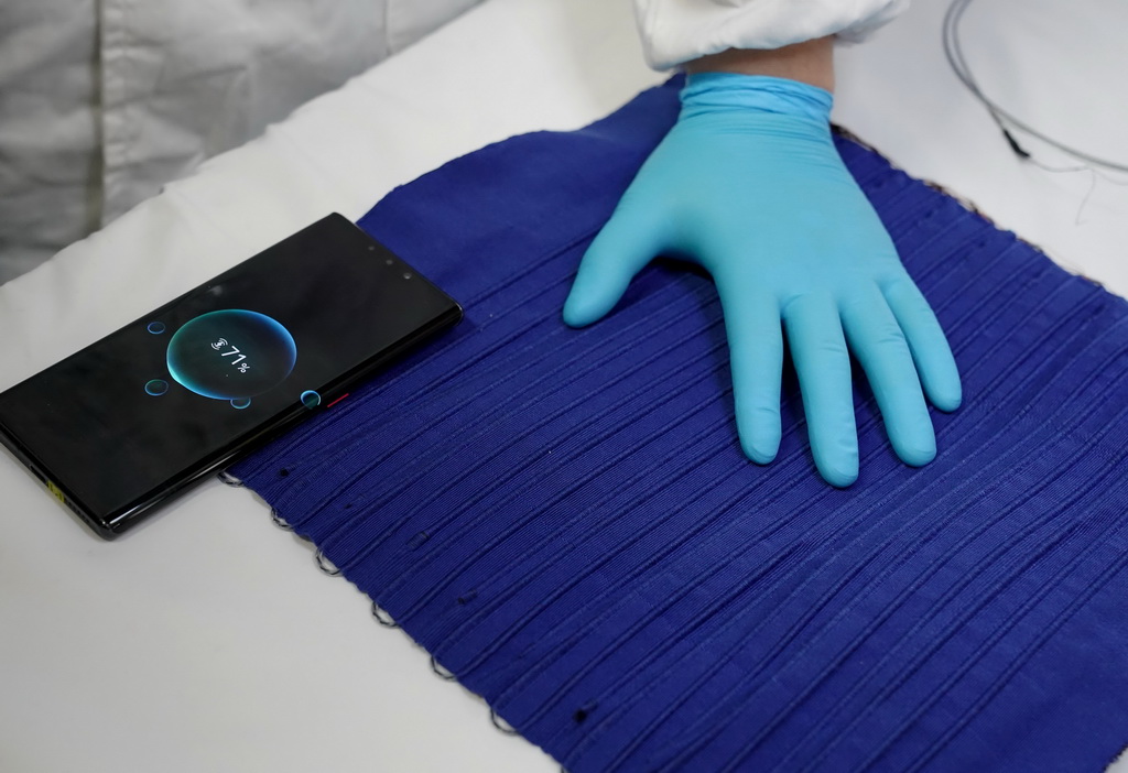 4月22日，復旦大學的研究人員展示手機可放在編織有纖維電池的織物上充電。