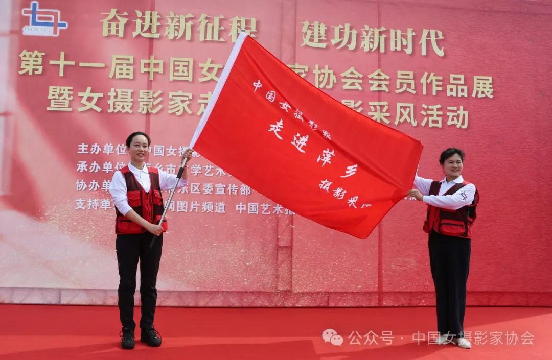 中國女攝影家協會副主席馮凱旋向萍鄉市女攝影家協會主席姚茜授中國女攝影家走進萍鄉市攝影採風旗。