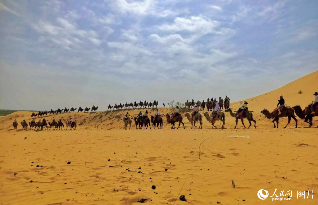 5月2日，游客在宁夏银川市黄沙古渡景区内骑骆驼。人民网记者 阎梦婕摄