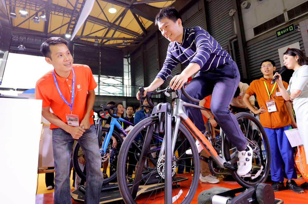 5月5日，一位參觀者在展會現場體驗騎行競速游戲。新華社記者 方喆 攝