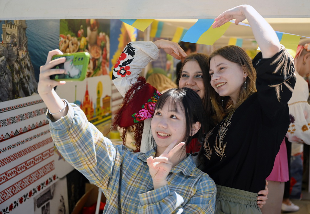 5月12日，一名中國學生在天津大學國際文化節上和留學生合影。