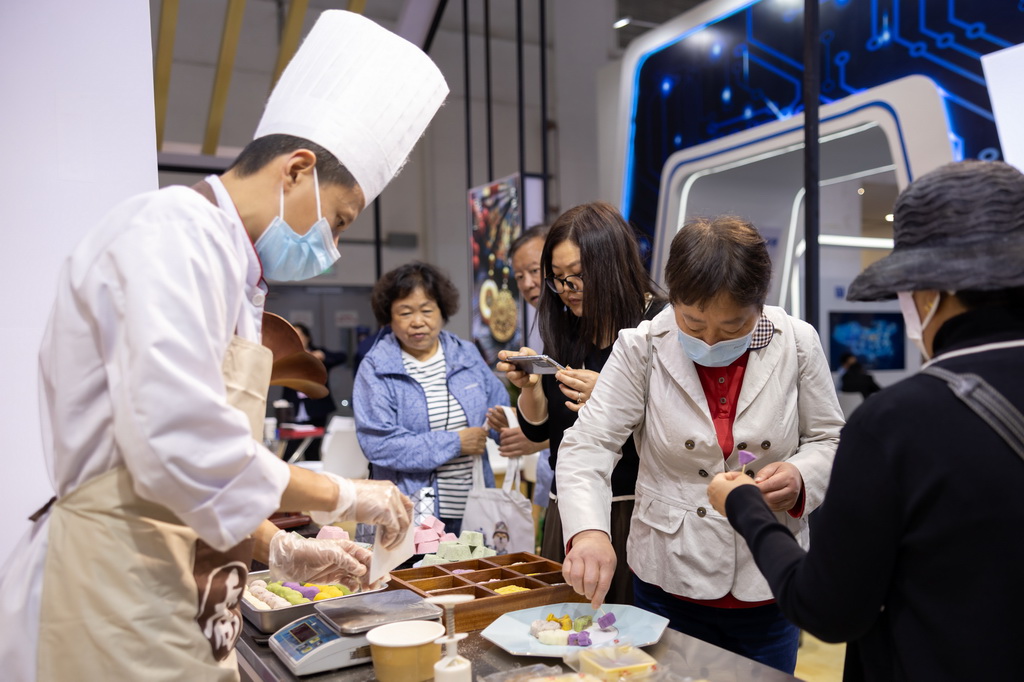 5月13日，觀眾在中華老字號“喬家柵”展位品嘗試吃現場制作的糕點。