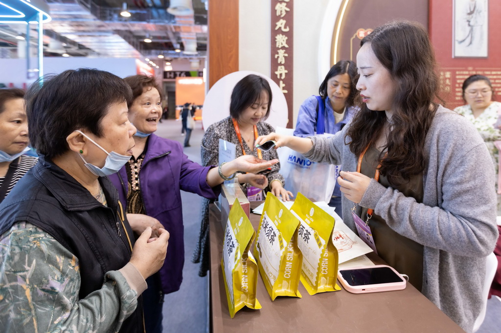 5月13日，人們在中華老字號“雷允上”展位試吃金銀花羅漢果糖。