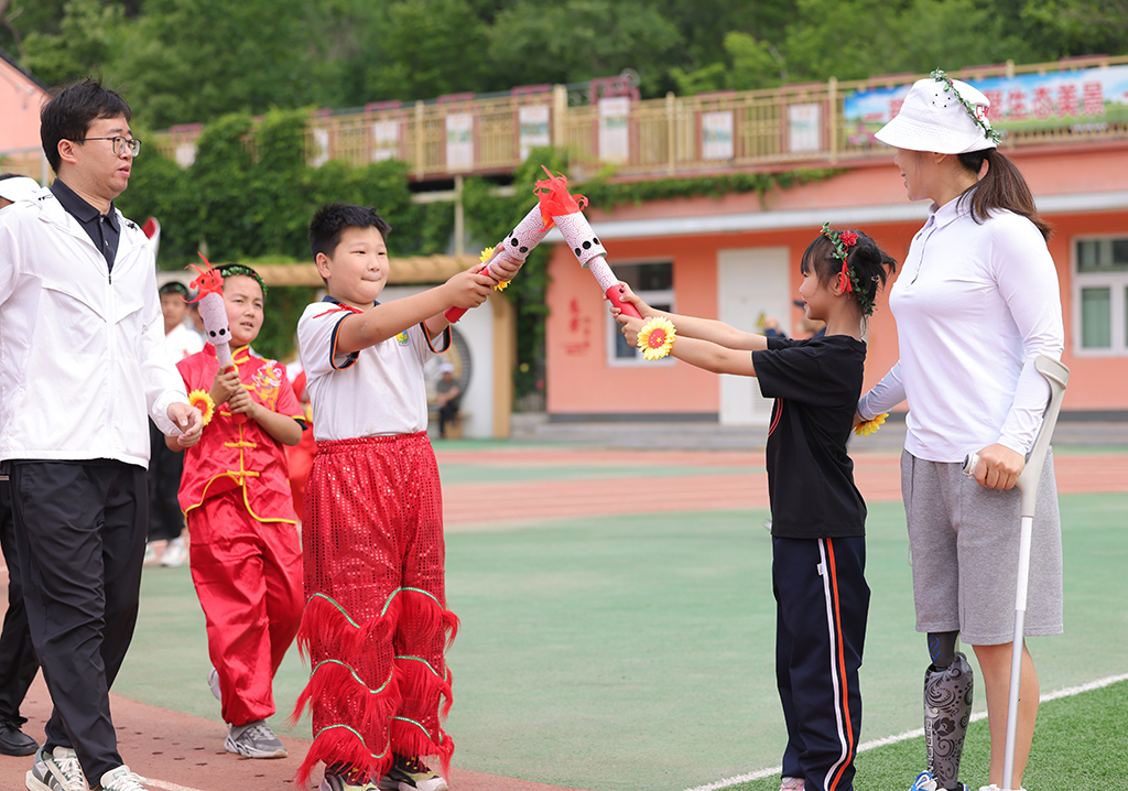 延慶區大庄科鄉中心小學迷你“奧運會”活動現場，師生們在模擬火炬傳遞儀式。