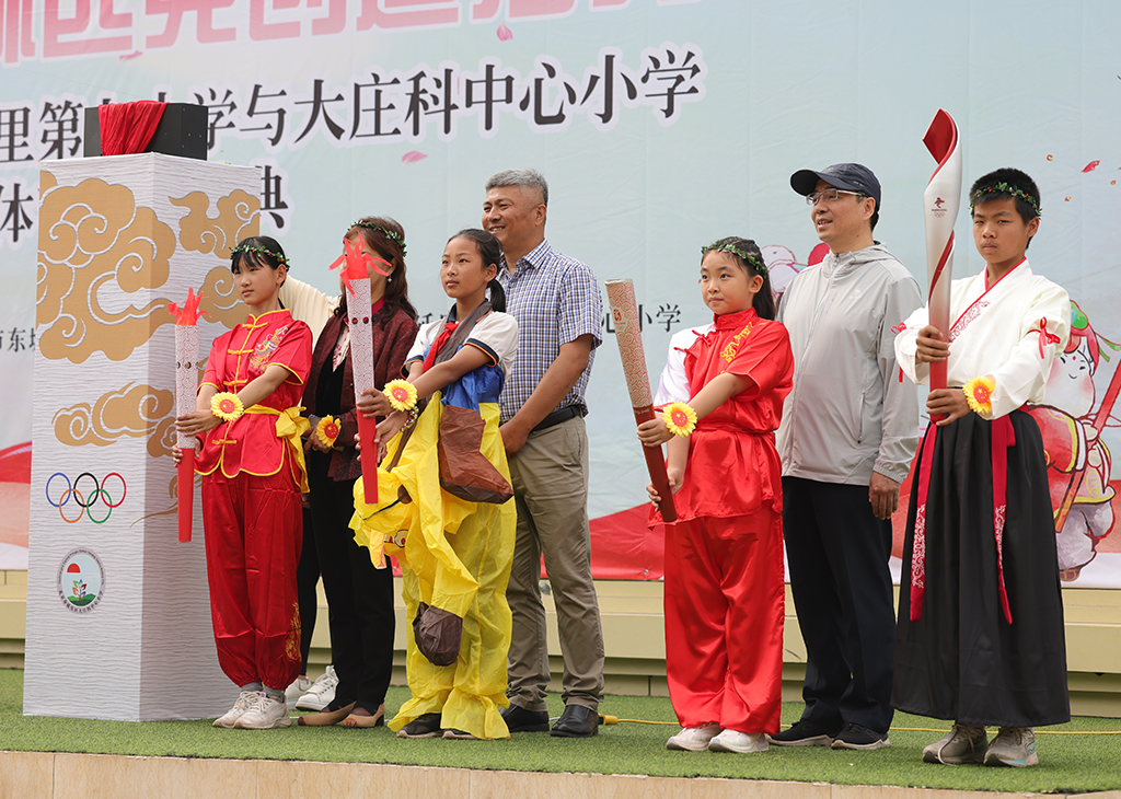 延慶區大庄科鄉中心小學迷你“奧運會”活動現場，師生們在模擬火炬點燃儀式。
