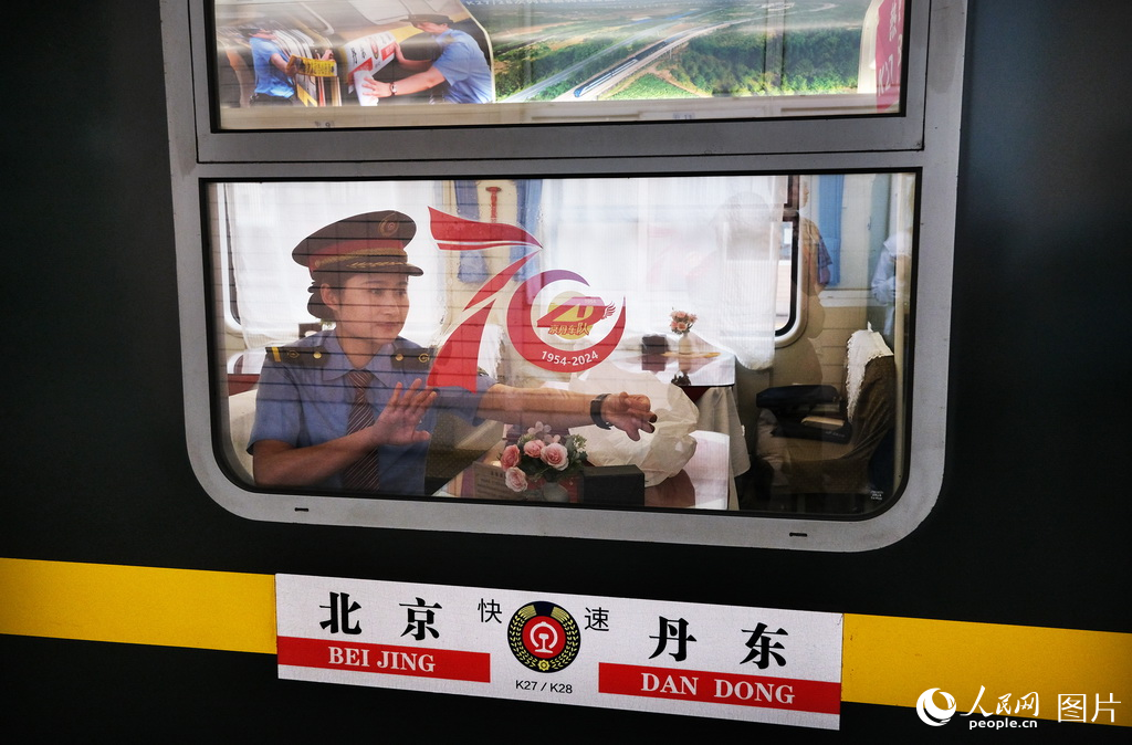5月30日，北京至丹東K27/28次列車迎來了開行70周年乘務人員在車窗上貼上慶祝70周年紀念貼。