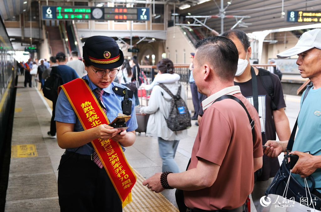 5月30日，北京至丹東K27/28次列車迎來了開行70周年乘務人員在北京站為旅客驗証乘車。