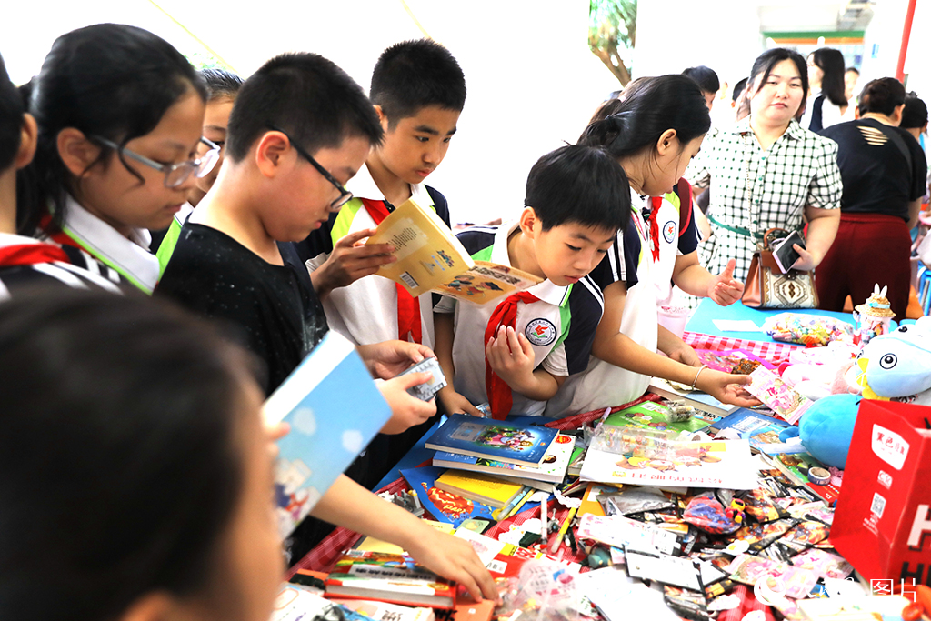 5月31日，海南海口市第二十五小學舉辦公益跳蚤市場活動，學生們在挑選自己喜愛的物品。 人民網記者 孟凡盛攝