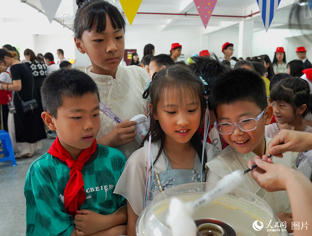 5月31日，在浙江省杭州第十四中學附屬學校裡，“歡樂六一，‘攤’玩一‘夏’”主題活動正在火熱舉行。孩子們穿自己喜歡的衣服，自由游園玩耍、享受美食。人民網記者 郭揚攝