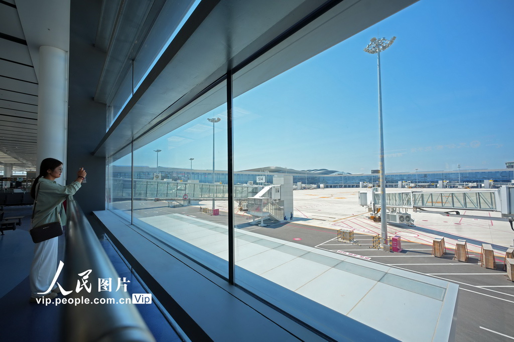 6月1日，模擬旅客在煙台蓬萊國際機場T2航站樓拍攝停機坪。