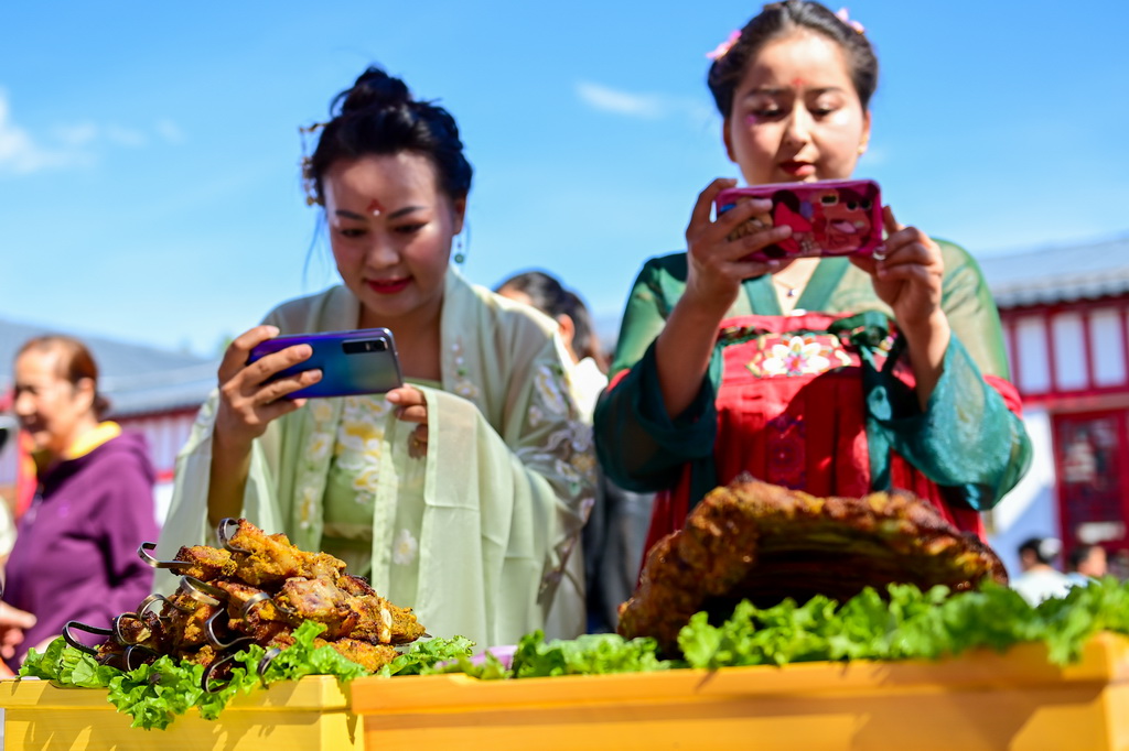6月2日，在新疆塔城地區裕民縣舉行的首屆巴什拜羊烹飪大賽上，觀眾在拍攝參賽菜品。