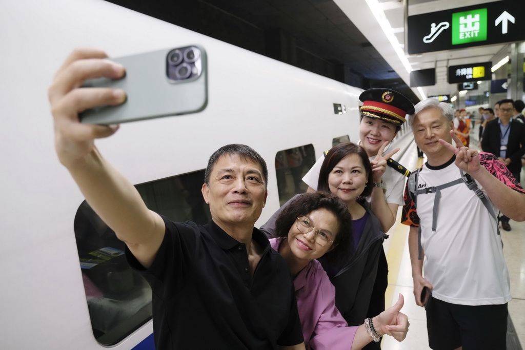 6月15日，乘坐香港西九龍至北京西D910次高鐵動臥列車的旅客在香港西九龍站站台上拍照留念。新華社記者 王申 攝