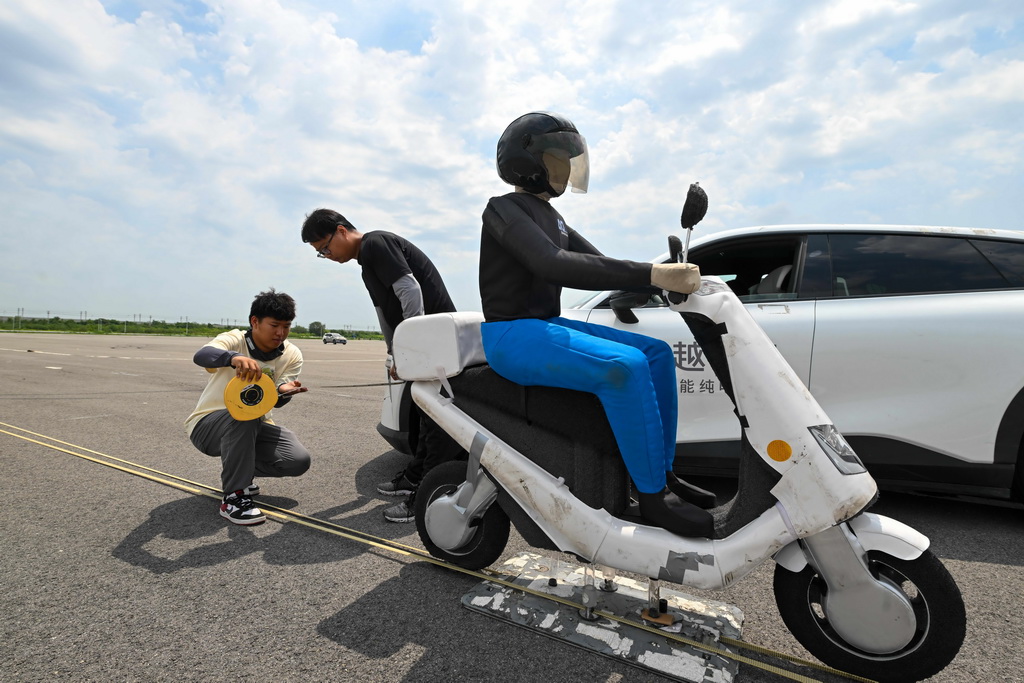 6月14日，測試人員對一款智能網聯汽車轉彎規避非機動車主動安全測試結果進行測量。