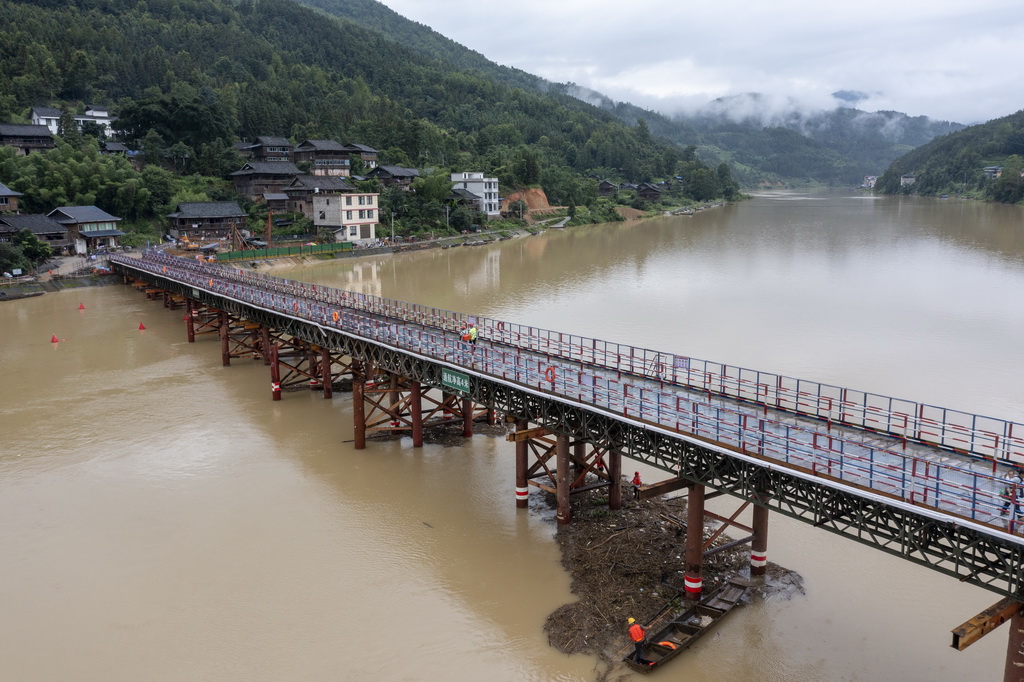 6月19日，工作人员在贵州省从江县下江镇�I温大桥钢栈桥下清理洪水堆积物（无人机照片）。新华社发（吴德军 摄）