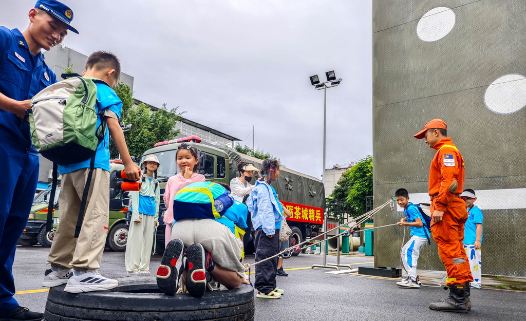 7月11日，在雲南省普洱市森林消防營區，參加研學活動的學生體驗滑輪在生活中的作用。新華社發（郭元首攝）