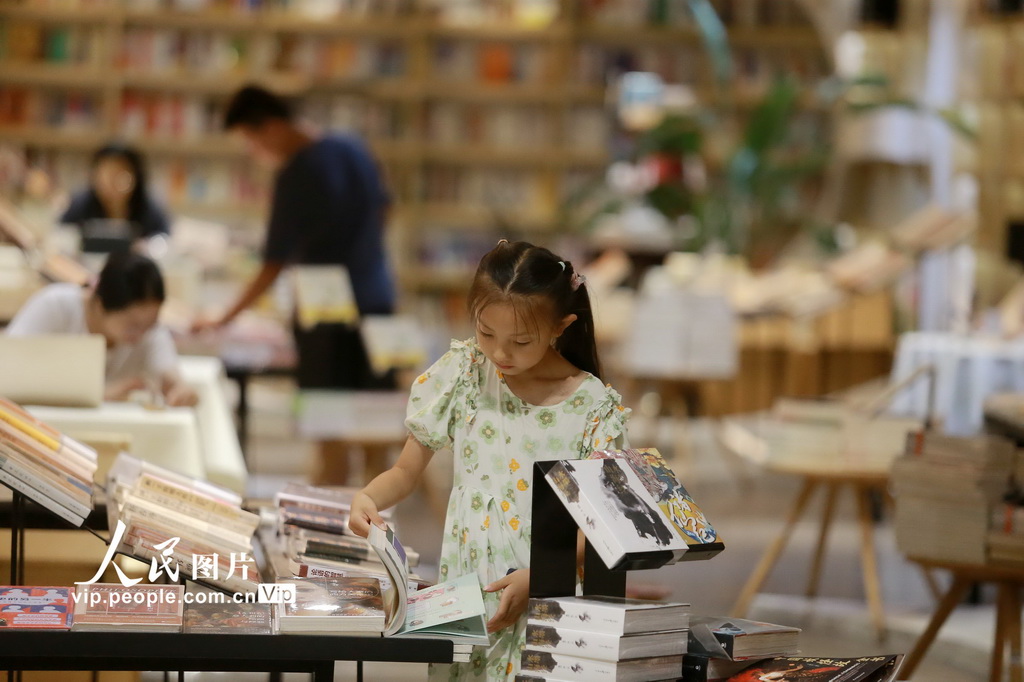 7月22日，小朋友在江蘇揚州的鐘書閣書店內讀書納涼。