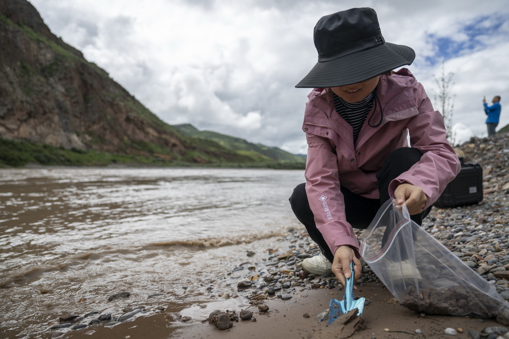 7月21日，長江科學院河流研究所的劉玉嬌在囊謙香達河段採集樣品。新華社記者 伍志尊 攝