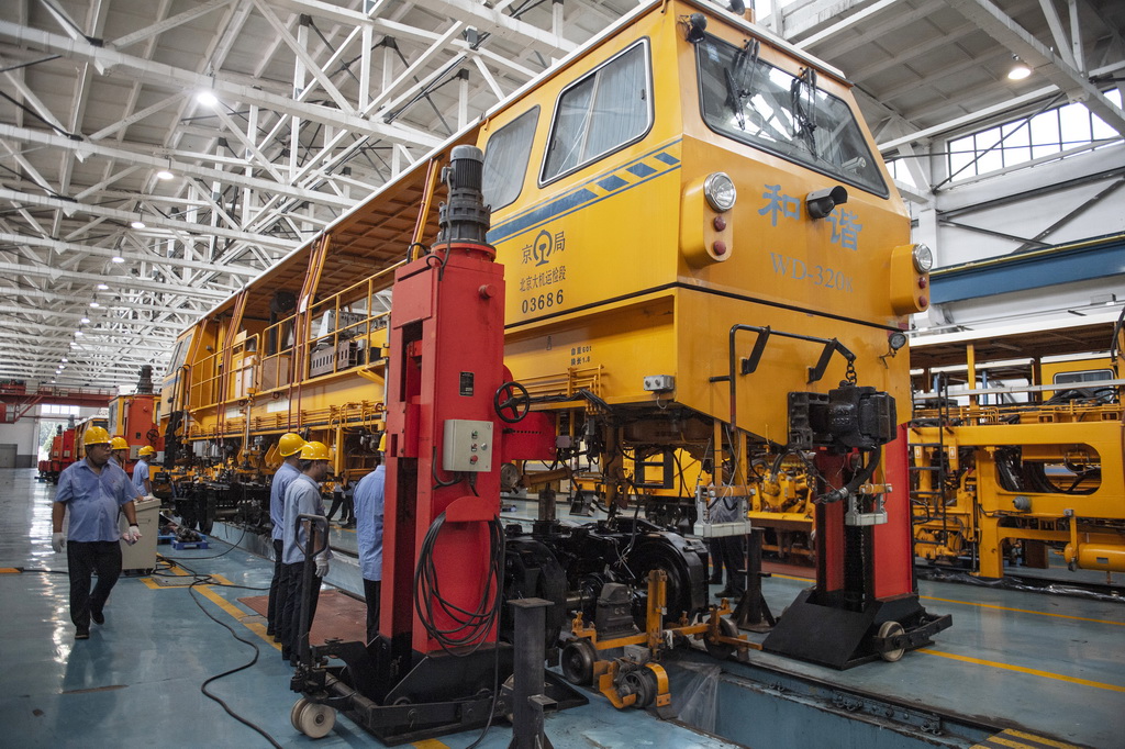 7月25日，在國鐵北京局北京大型養路機械運用檢修段的檢修庫，職工們進行架車作業。