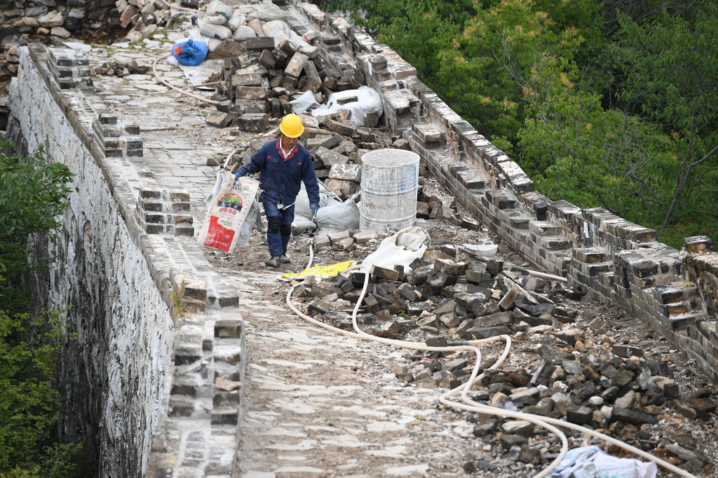 工人在箭扣長城122號敵台東側牆體修繕施工現場（7月2日攝）。