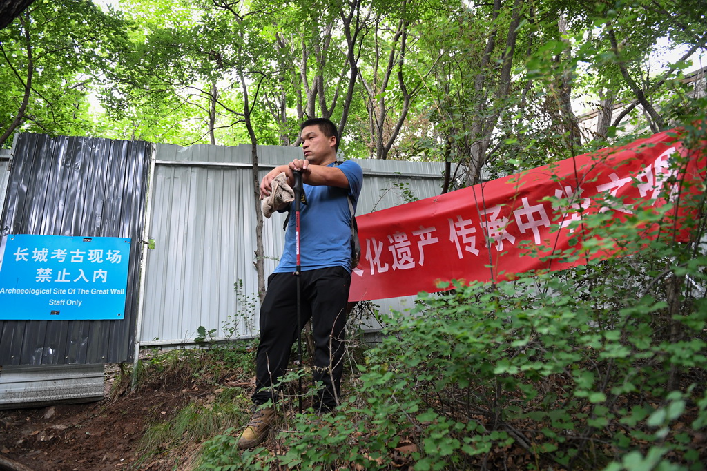 負責考古現場的技工楊戰杰抵達箭扣長城考古現場，等待保安開門（7月2日攝）。