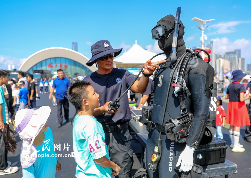 8月18日，特警隊員在給小朋友講解潛水服如何使用。