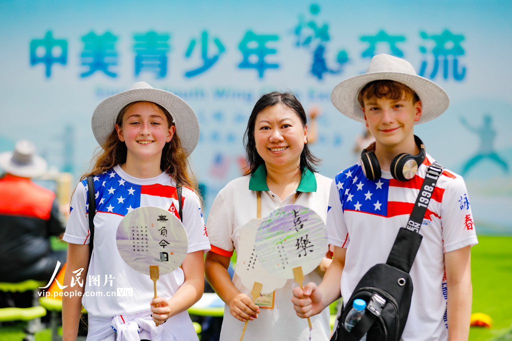 8月26日，福建省福清市百合小学第二校区，老师和美国青少年一同展示漆扇成品。