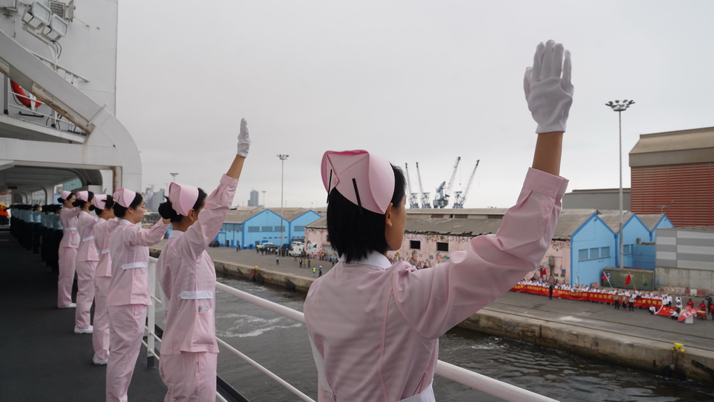 當地時間9月11日，中國海軍“和平方舟”號醫院船駛離安哥拉羅安達港，醫護人員揮別送行人群。