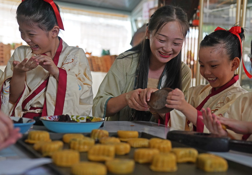 9月11日，孩子們在老師（中）的指導下體驗傳統手工月餅制作。