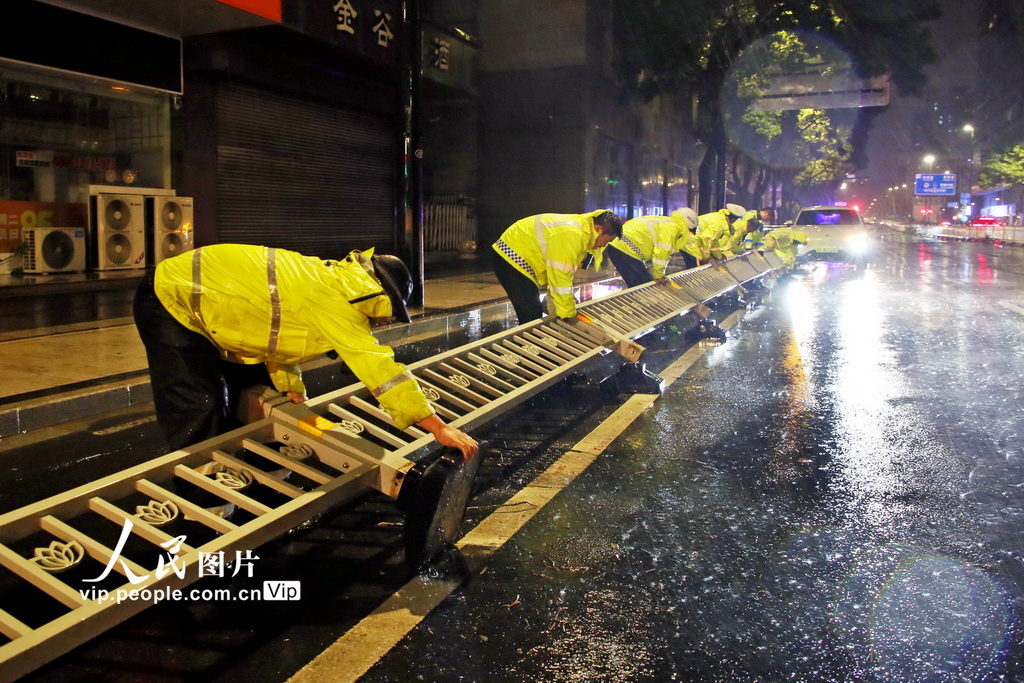 9月16日晚，交管部門人員在扶起被台風“貝碧嘉”吹倒的護欄。