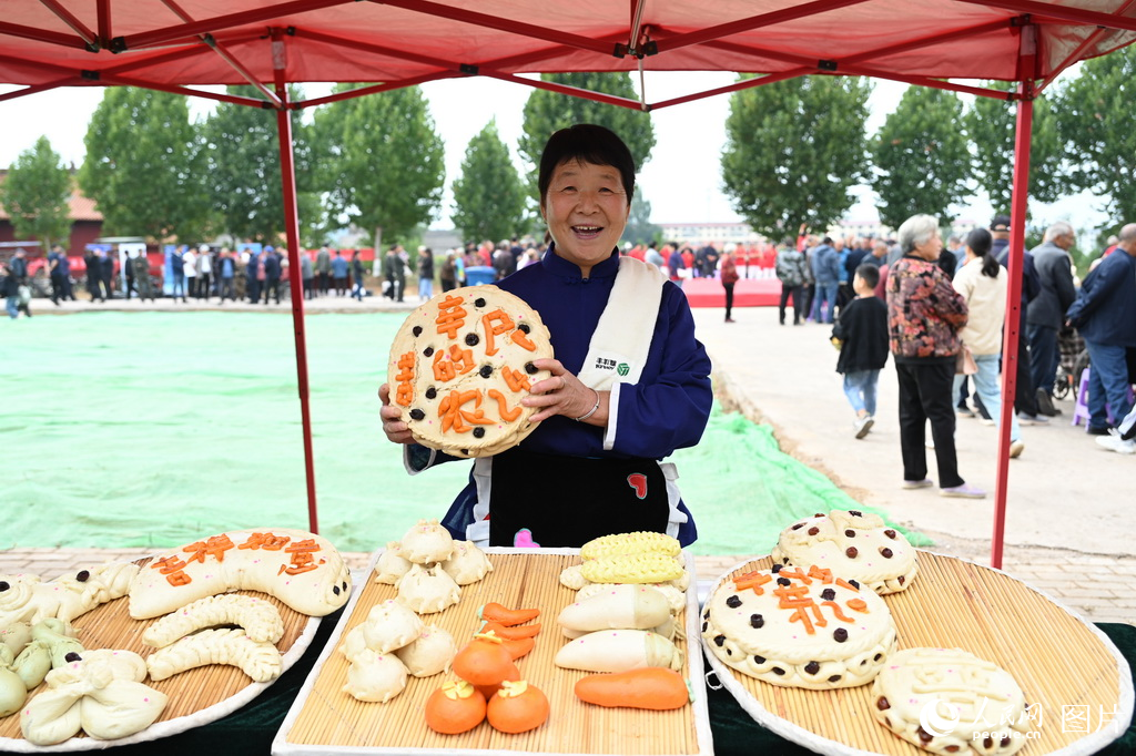  On the morning of September 22, the main venue of the 2024 Chinese Farmers' Harvest Festival in Jiyuan, Henan Province, was held in Beizhai Village, Shaoyuan Town. Zhai Xiaozhen, a local villager, was demonstrating his traditional steamed buns. Photographed by Wang Yuxing, reporter of People's Daily Online