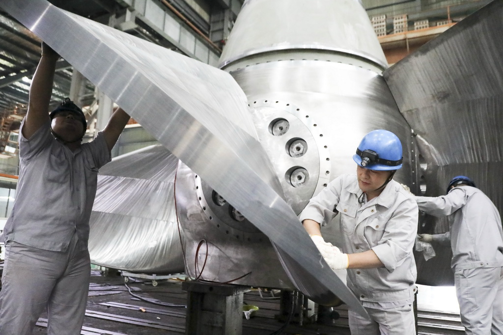  10月8日，在浙江省杭州市桐庐县富春江镇的一家水电设备制造企业，工人在车间内装配机组转轮。新华社发（徐军勇摄）