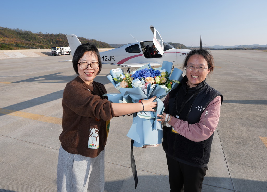 10月13日，在陝西延安機場，工作人員迎接駕機抵達的女飛行員吳運娟（右）。