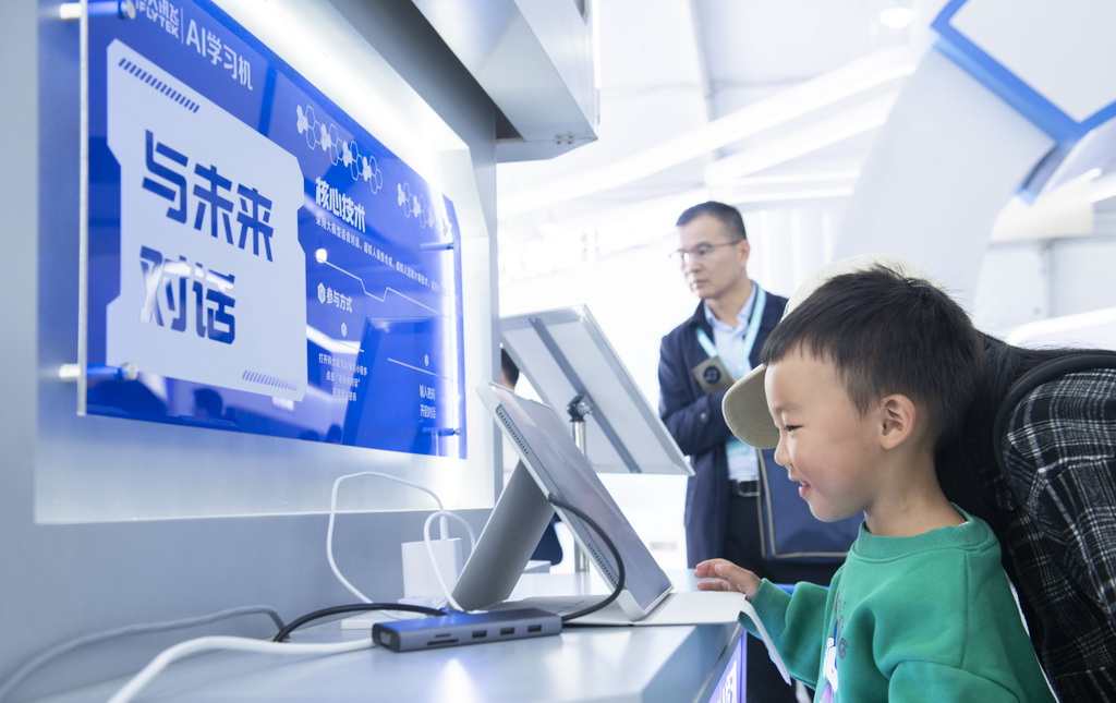10月24日，一名儿童在第七届世界声博会上体验一款AI学习机。