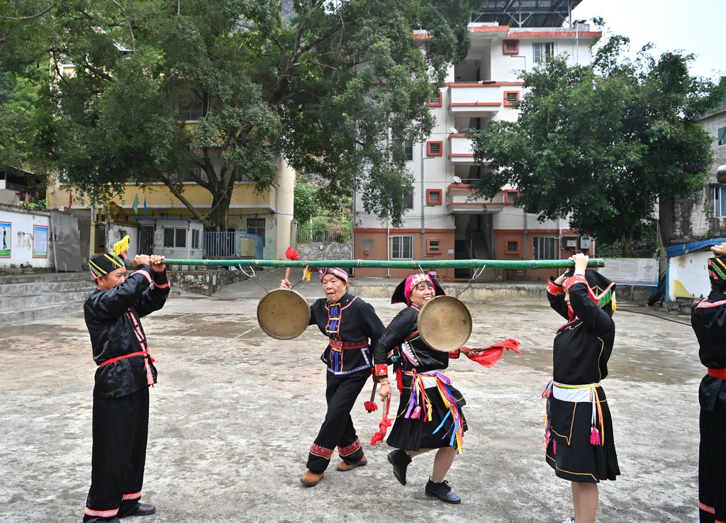 阮桂陆（左二）和艺术团成员在田东县作登瑶族乡梅林村表演金锣舞（10月28日摄）。