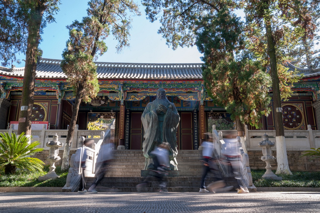 11月12日，在雲南省會澤縣第一中學，學生們走在校園內的孔子像前。