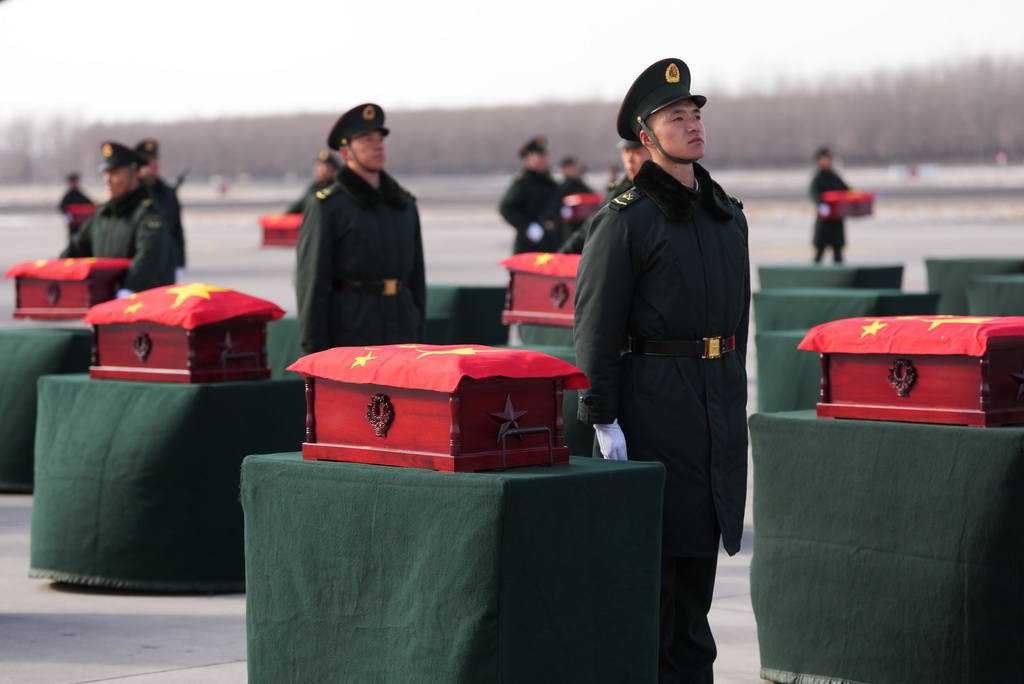 11月28日，在沈阳桃仙国际机场，礼兵将殓放志愿军烈士遗骸的棺椁从专机上护送至棺椁摆放区。新华社记者 李钢 摄