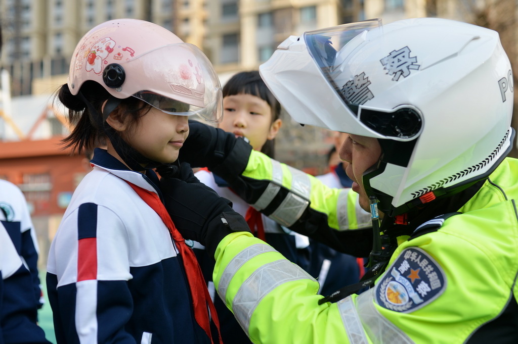 12月1日，在山東青島吉林路小學，小朋友學習如何正確佩戴兒童頭盔。新華社發（王海濱攝）