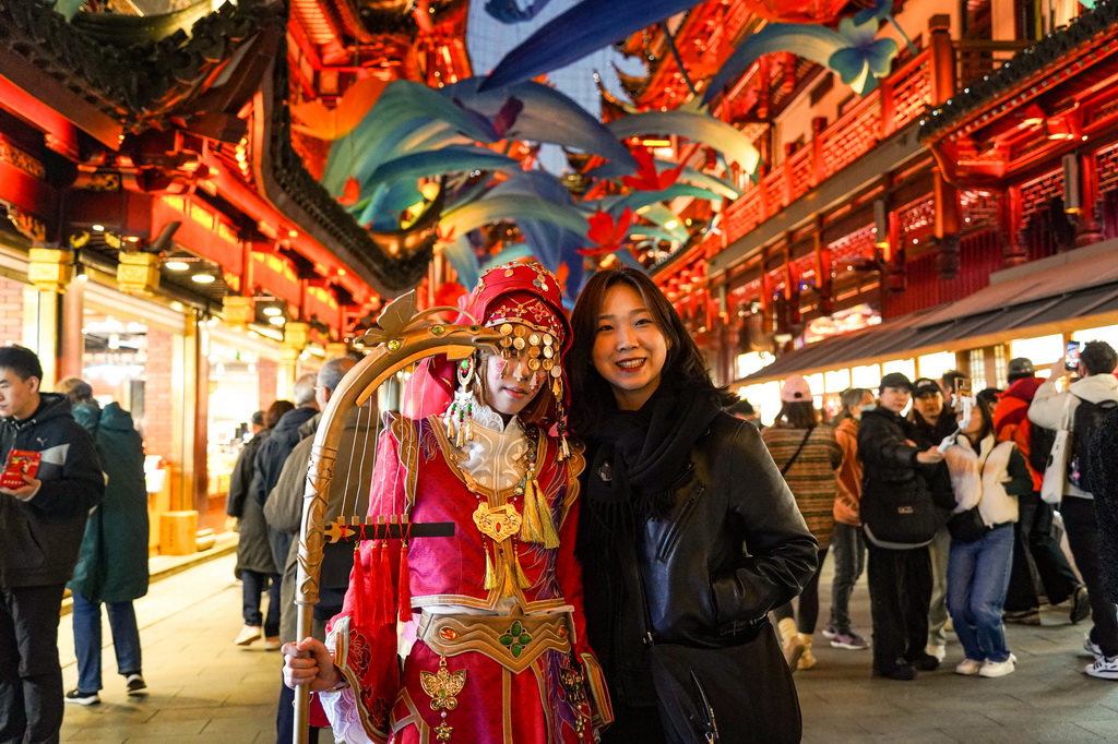 11月30日，來自韓國的游客（右）在上海豫園商城與游戲角色裝扮者合影。新華社發（謝鑫 攝）
