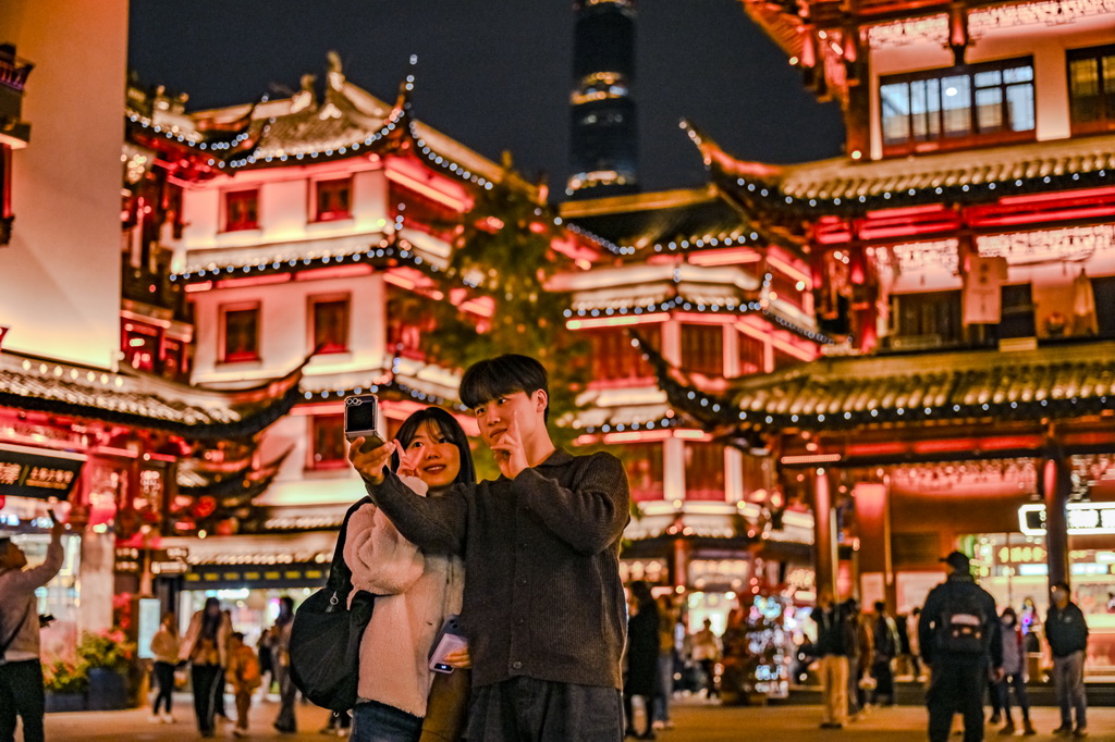 12月4日，来自韩国的游客在上海豫园商城自拍。新华社发（陈浩明 摄）