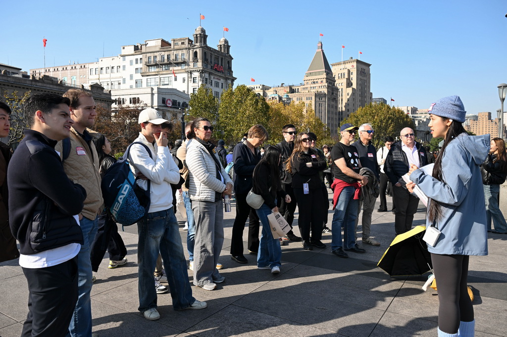 11月30日，外国游客在上海外滩听导游讲解。新华社发（陈浩明 摄）