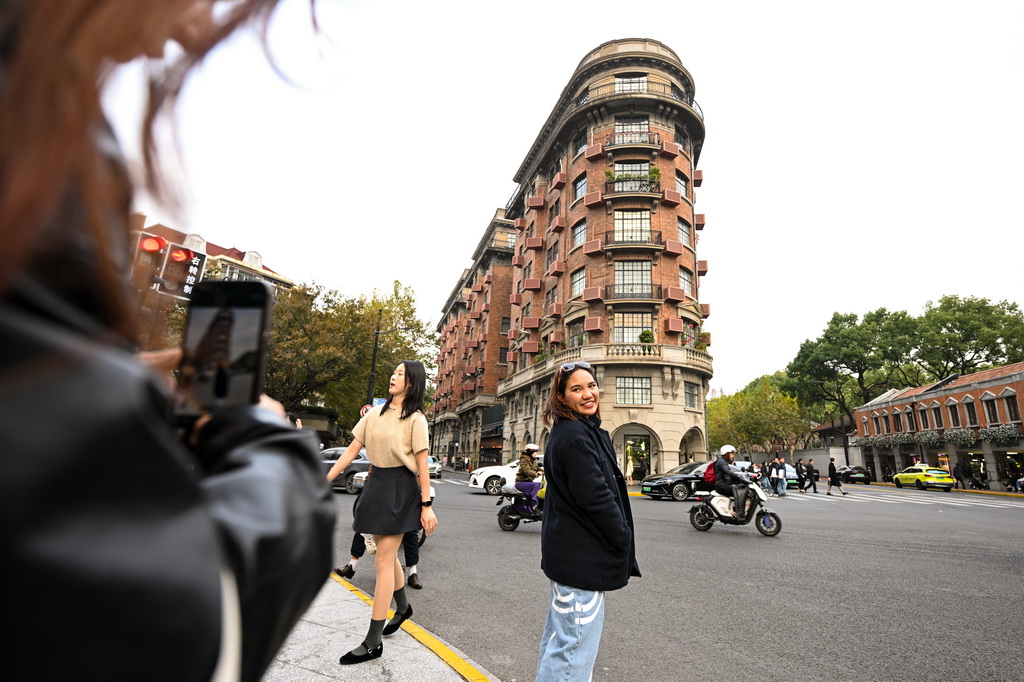 12月3日，来自泰国的游客在上海武康大楼前打卡拍照。新华社发（陈浩明 摄）