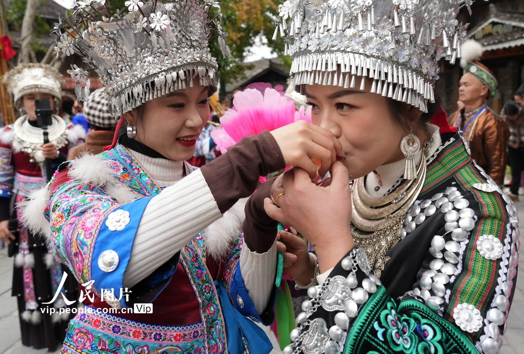 12月22日，在广西柳州市融水苗族自治县融水镇梦呜苗寨，主寨“同年”（左）在“迎同年”仪式中向客寨“同年”敬进寨酒。