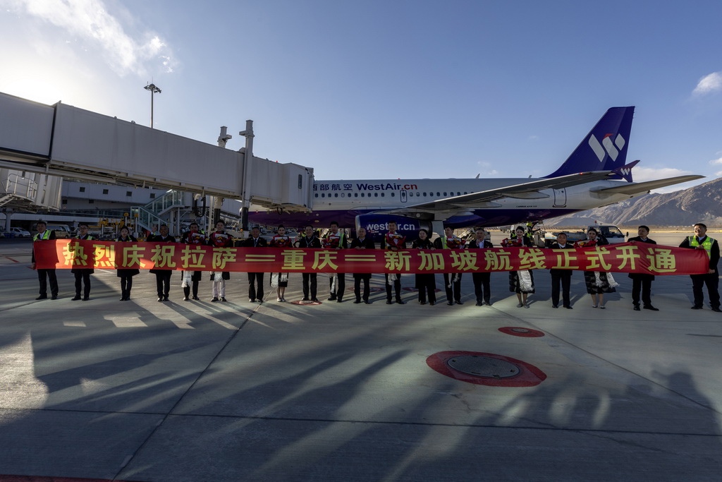 12月25日，拉萨地面人员与西部航空PN6425客运航班机组人员在拉萨贡嘎国际机场合影留念。新华社记者 姜帆 摄