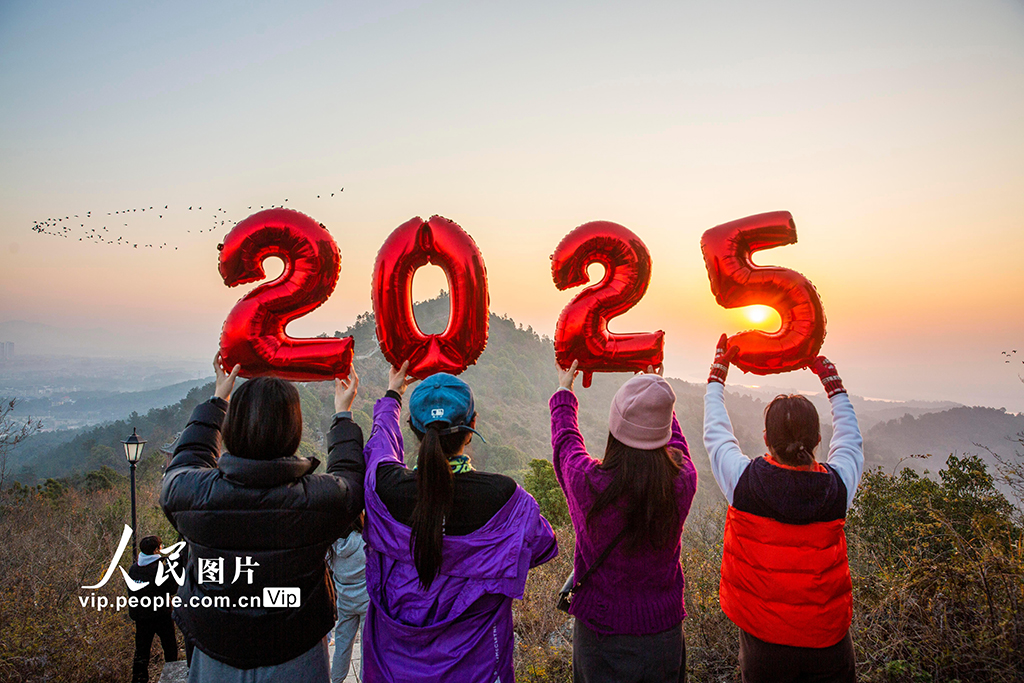 2025年1月1日，人们在江西省九江市都昌县南山举起“2025”字样迎接新年第一缕阳光。傅建斌摄（人民图片网）