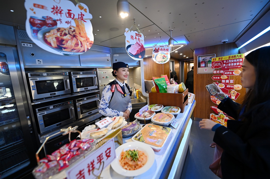 1月5日，担当陕港列车值乘任务的“长安之馨”西港乘务人员为旅客介绍餐车服务情况。