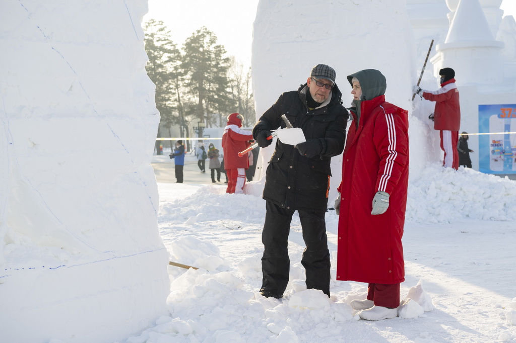 1月6日，在哈尔滨太阳岛雪博会园区，参赛选手在雕刻雪雕作品的间隙交流。新华社记者 谢剑飞 摄