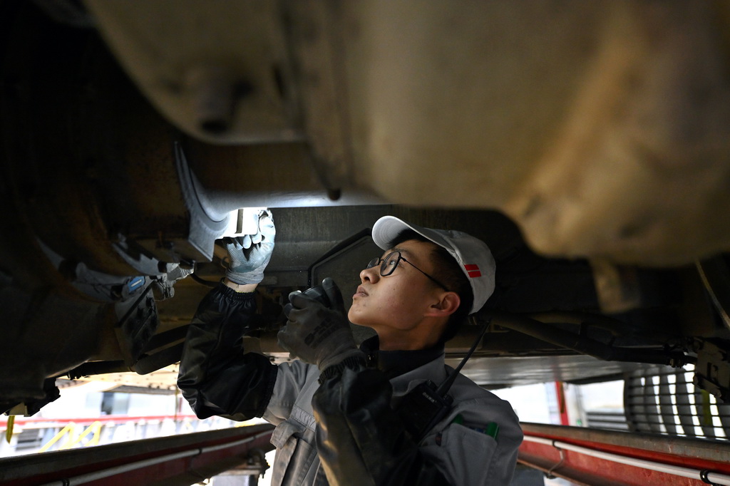 1月9日，動車組機械師在太原動車組運用所檢查列車底部。