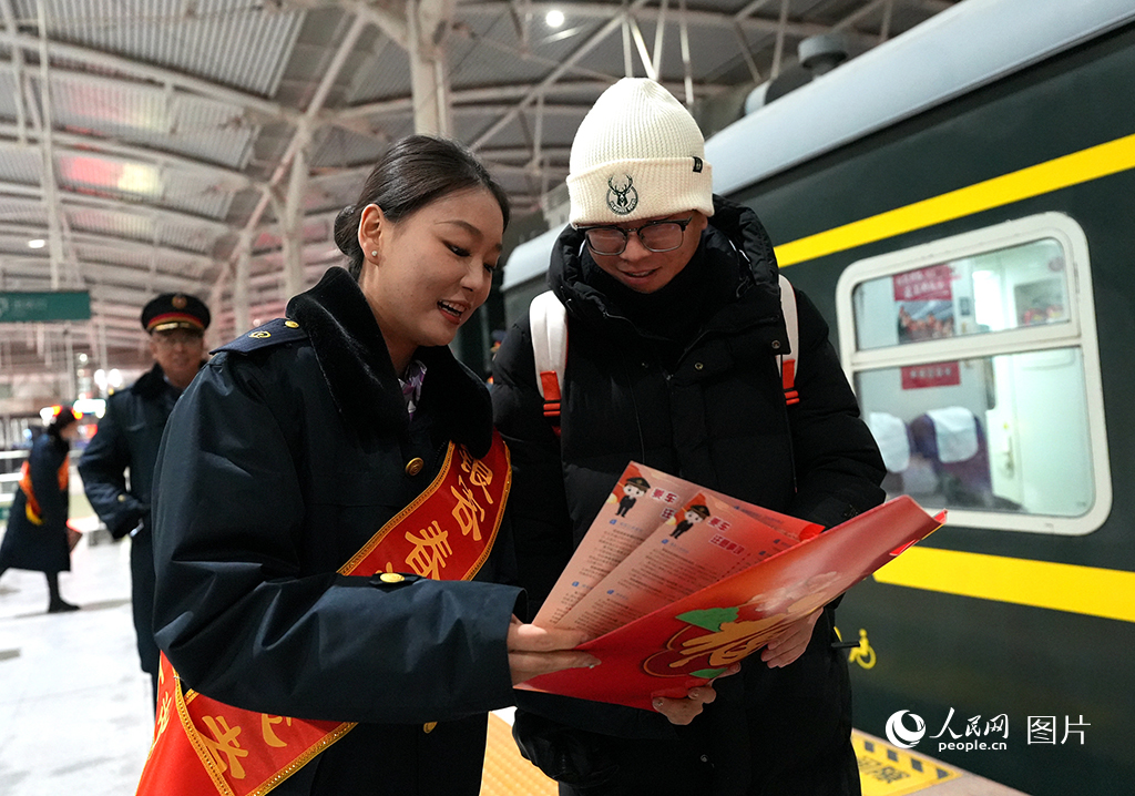 2025年春运首日，银川火车站工作人员为旅客讲解乘车注意事项。人民网记者 梁宏鑫摄